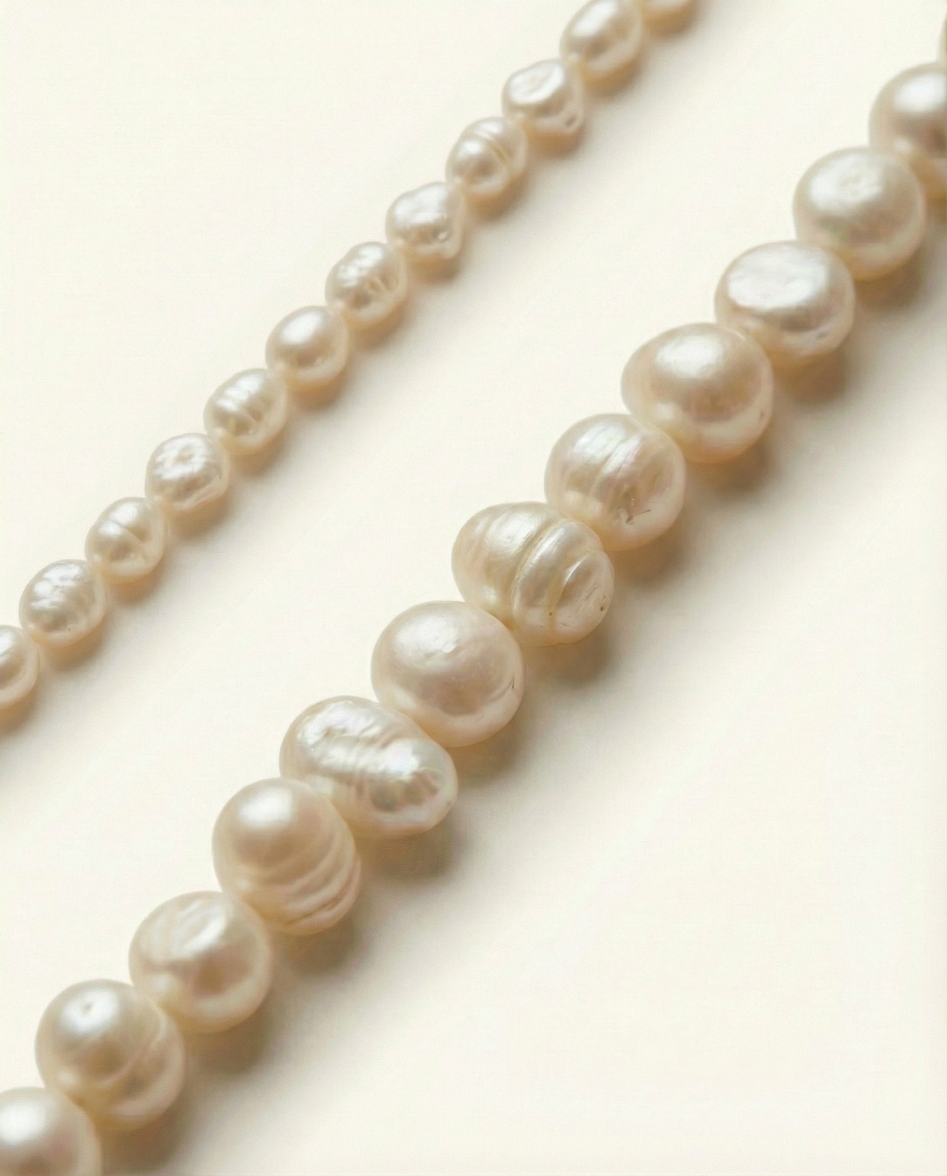 Pearl necklace on a light beige background
