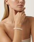 Woman wearing pearl bracelet in studio setting.