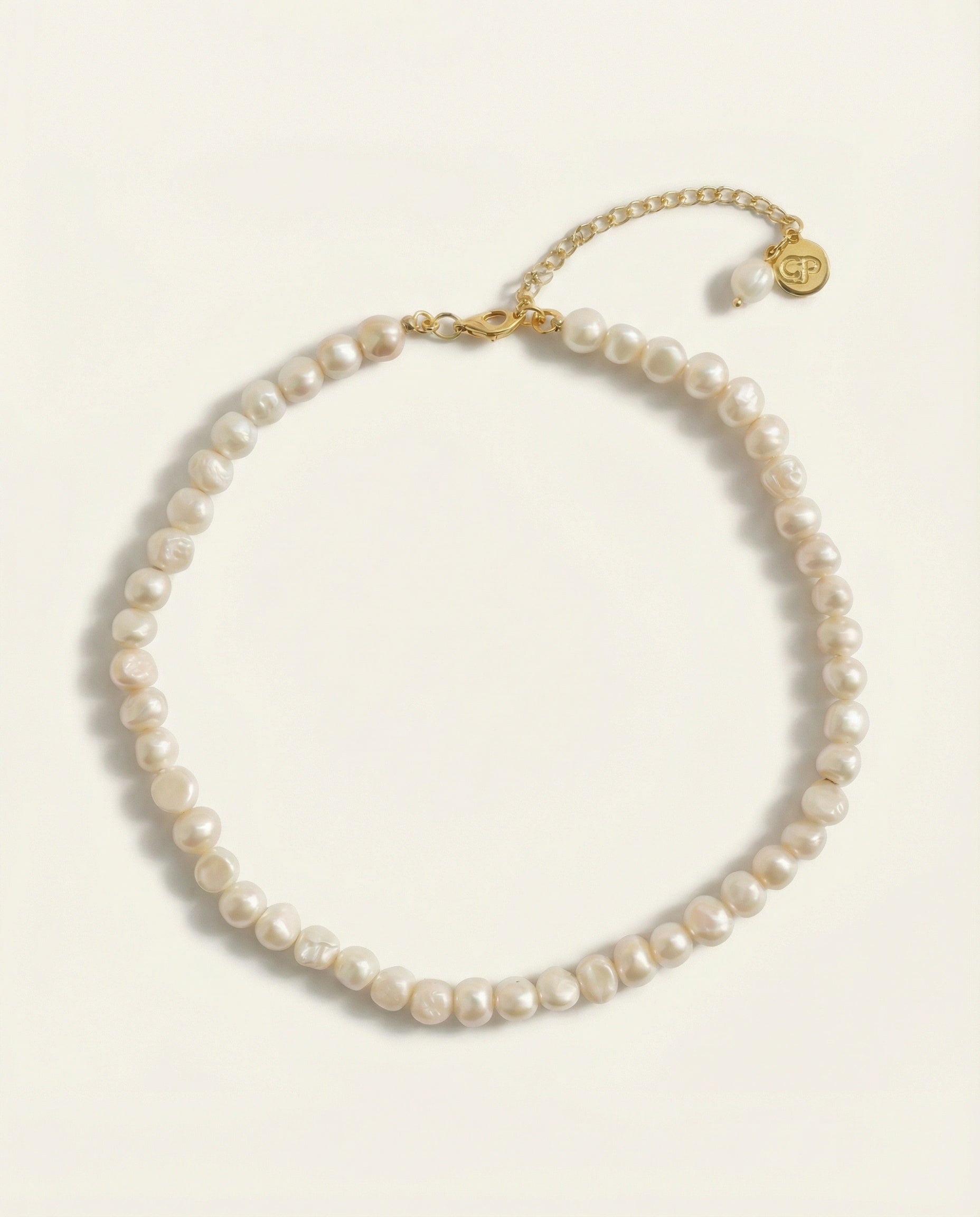 Pearl necklace with gold clasp on a white background
