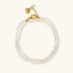 A double-wrap bracelet featuring handpicked, genuine freshwater pearls and a gold vermeil clasp with a small pearl attached to it.